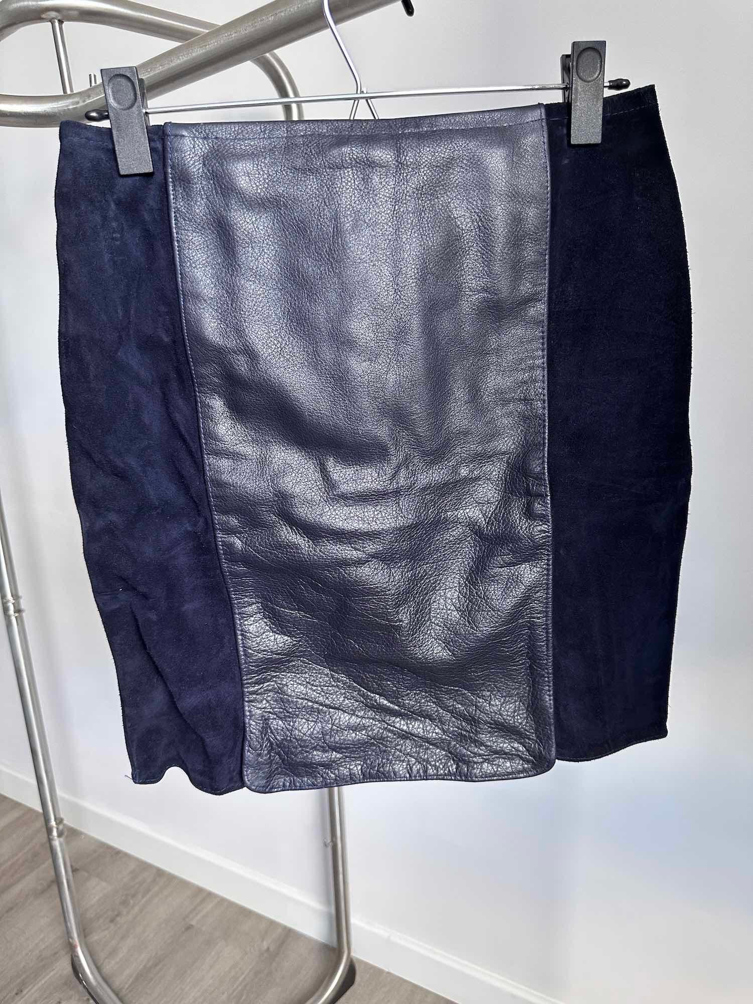 Vue de face d'une jupe en cuir bi-matière de seconde main, travail artisanal fait main de qualité supérieure disponible sur notre friperie en ligne.
