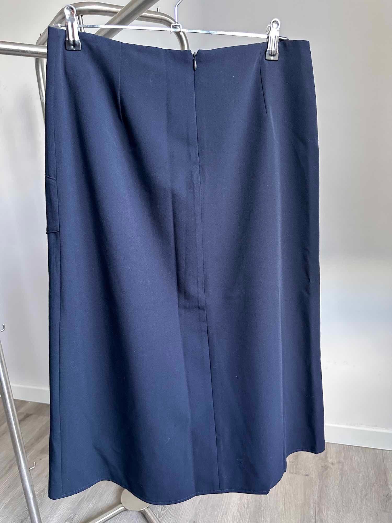 Vue de dos d'une jupe droite bleu marine de seconde main avec coutures asymétriques, mode chic et de qualité à petit prix en friperie en ligne.