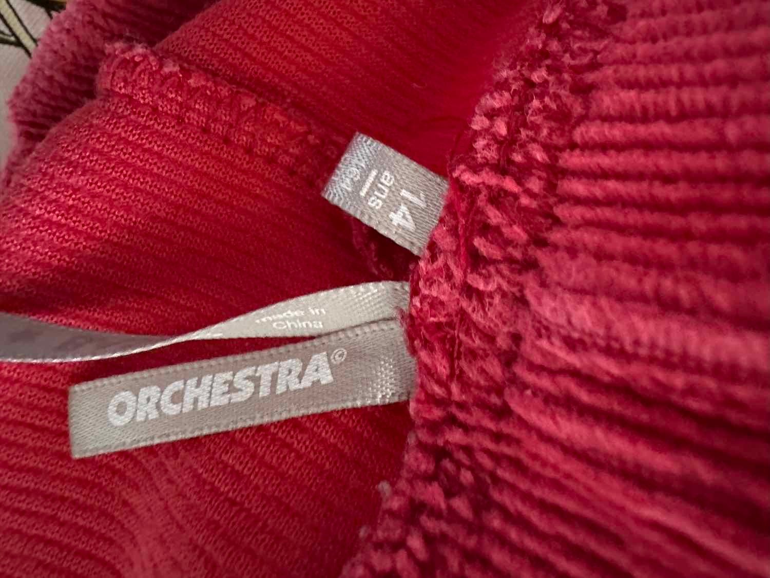 Gros plan sur l'étiquette intérieure du pantalon indiquant la marque Orchestra et la taille 14 ans 164 cm