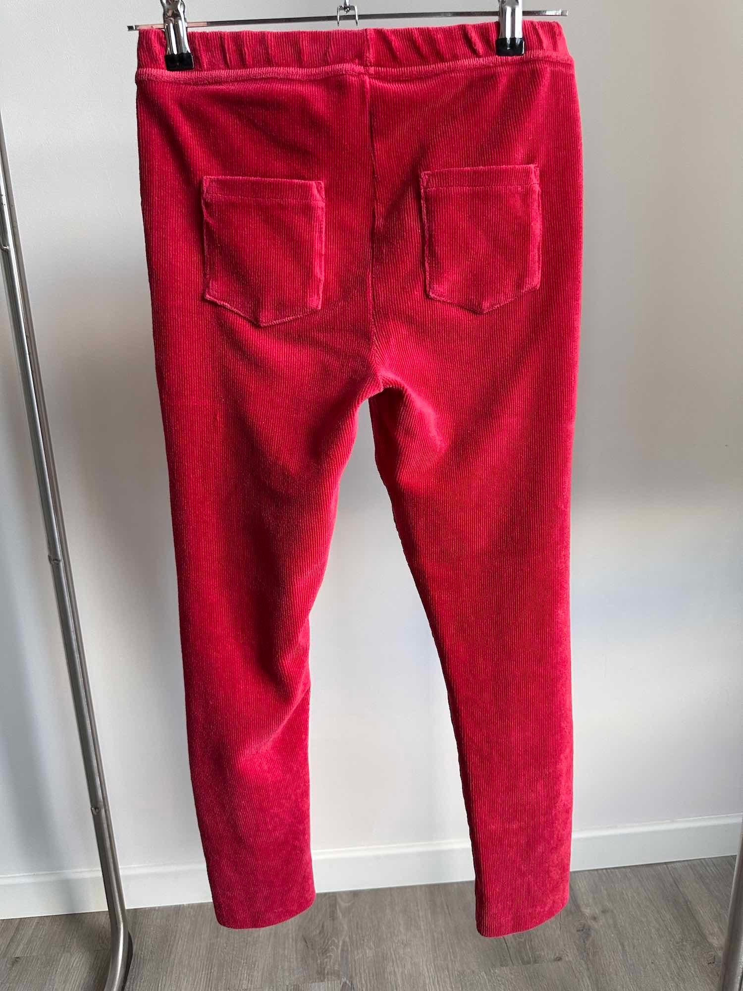 Vue de dos d'un pantalon rouge en velours avec deux poches arrière sur un cintre