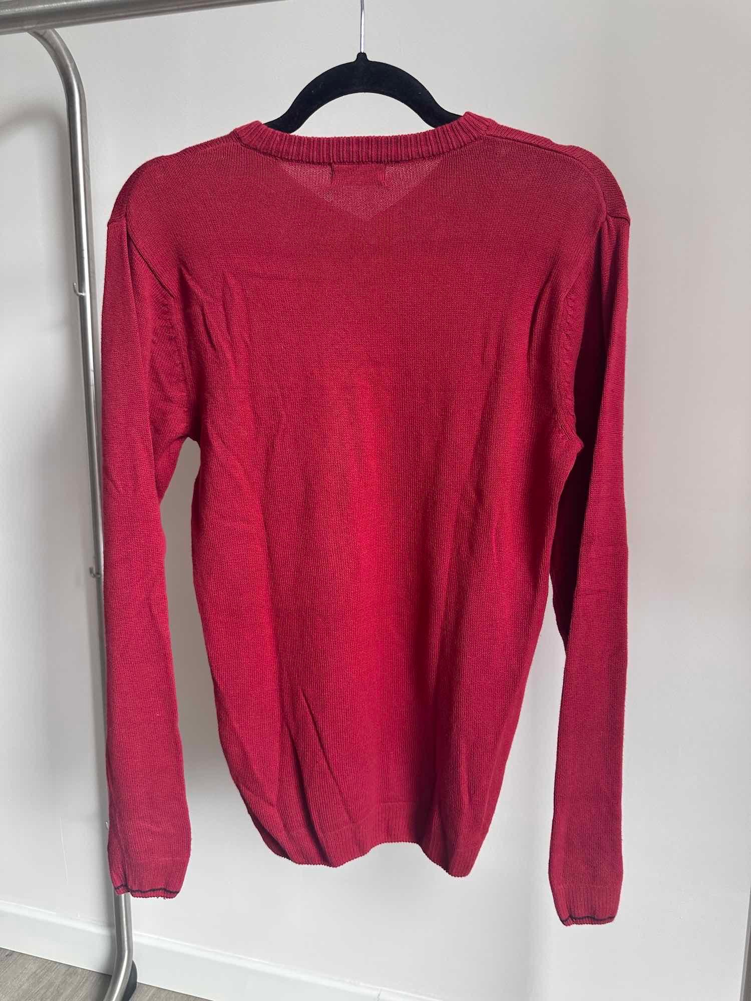 Vue de dos d'un pull rouge taille S sur un cintre