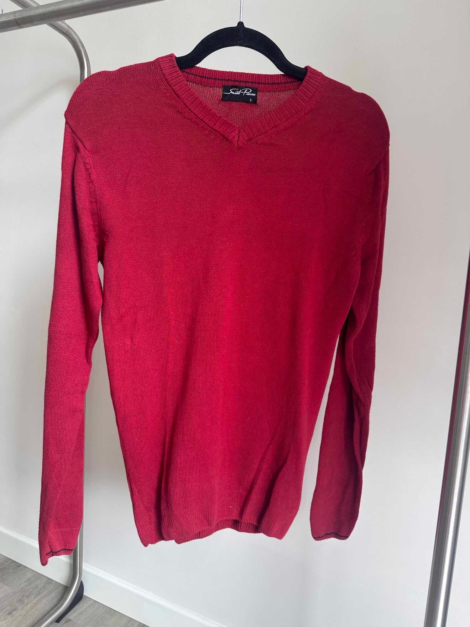 Vue de face d'un pull homme rouge col V sur un cintre