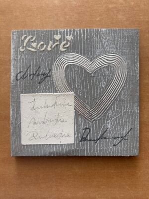 Tableau carré avec un cœur argenté en relief sur fond gris texturé