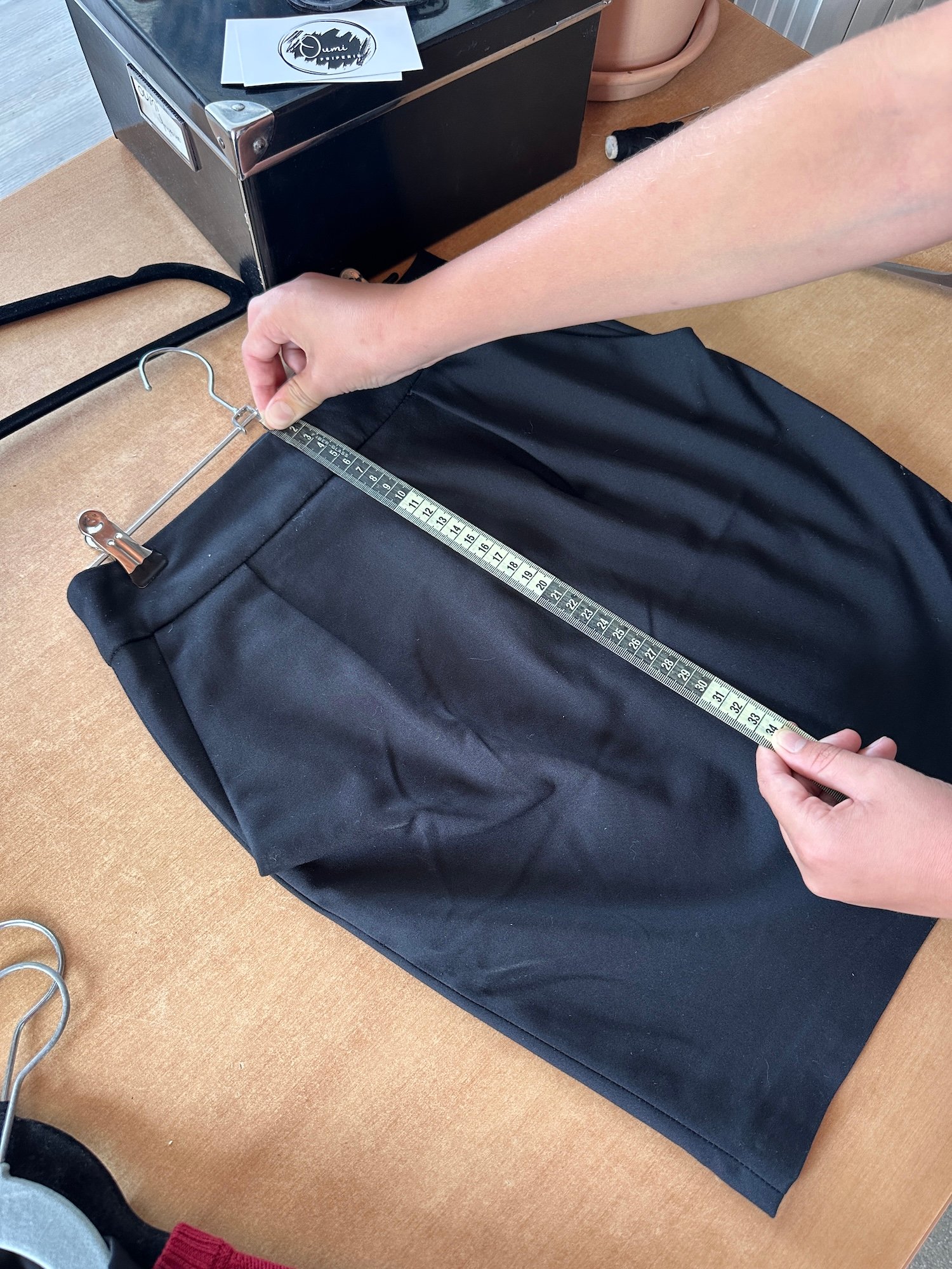 Mesure de la longueur totale d'une jupe seconde main à plat, du haut de la ceinture à l'ourlet